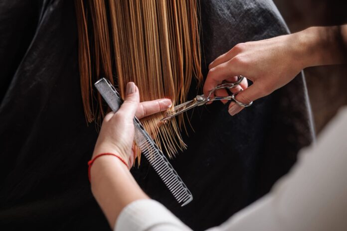 Parrucchiera taglia i capelli a una cliente
