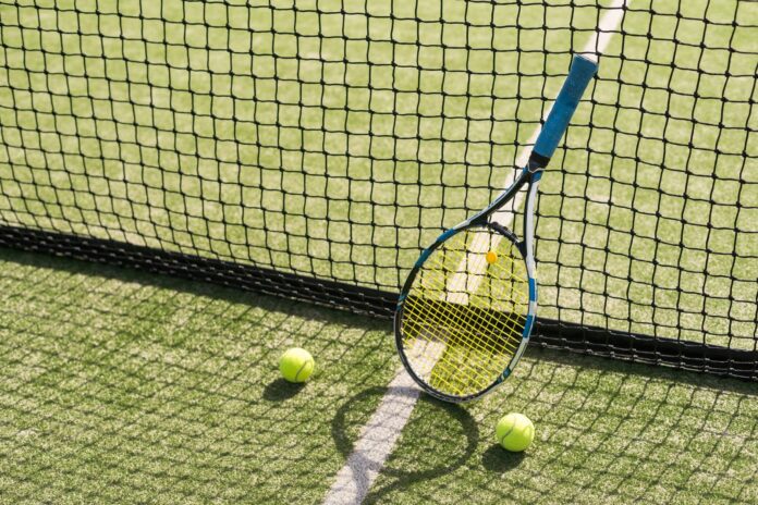 Racchetta e due palline su un campo da tennis