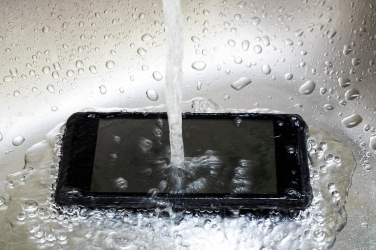 Un telefono nero viene bagnato dall'acqua