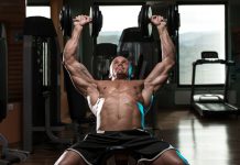 Allenamento: frasi motivazionali per non arrenderti mai Un uomo a petto nudo fa allenamento in palestra sollevando pesi